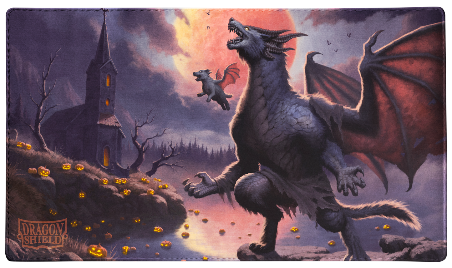 A Halloween-themed TCG Playmat featuring a large dragon and a smaller dragon flying in front of a blood moon, with a spooky church and jack-o'-lanterns on a hill. Brand: Dragon Shield, Item: Halloween 2023 - TCG Playmat.