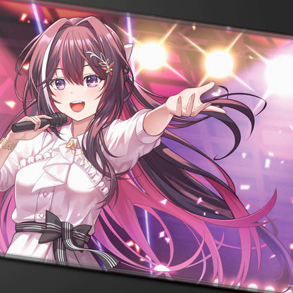 A pink and purple anime-style playmat featuring AZKi singing into a microphone on stage. Brand: hololive, Item: AZKi Stitched Playmat for the hololive OFFICIAL CARD GAME.