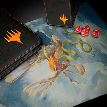 A black binder and deck box with orange Magic: The Gathering logos on a playmat featuring artwork of a bird-like creature with a green ribbon.