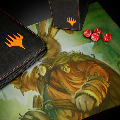 A black deck box and binder with orange Magic: The Gathering logos, alongside red dice and a Bloomburrow Finneas, Ace Archer playmat.