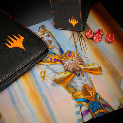 A black deck box and playmat featuring the Magic: The Gathering logo and artwork of a mummy-like figure in Egyptian-inspired armor. Brand: Magic: The Gathering, Item: Aetherdrift Amonkhet Eternal Might (Commander) Playmat.