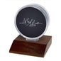 A dark wood base hockey puck display holder with a clear case. Brand: Ultra PRO, Item: Hockey Puck Dark Wood Base Display Holder