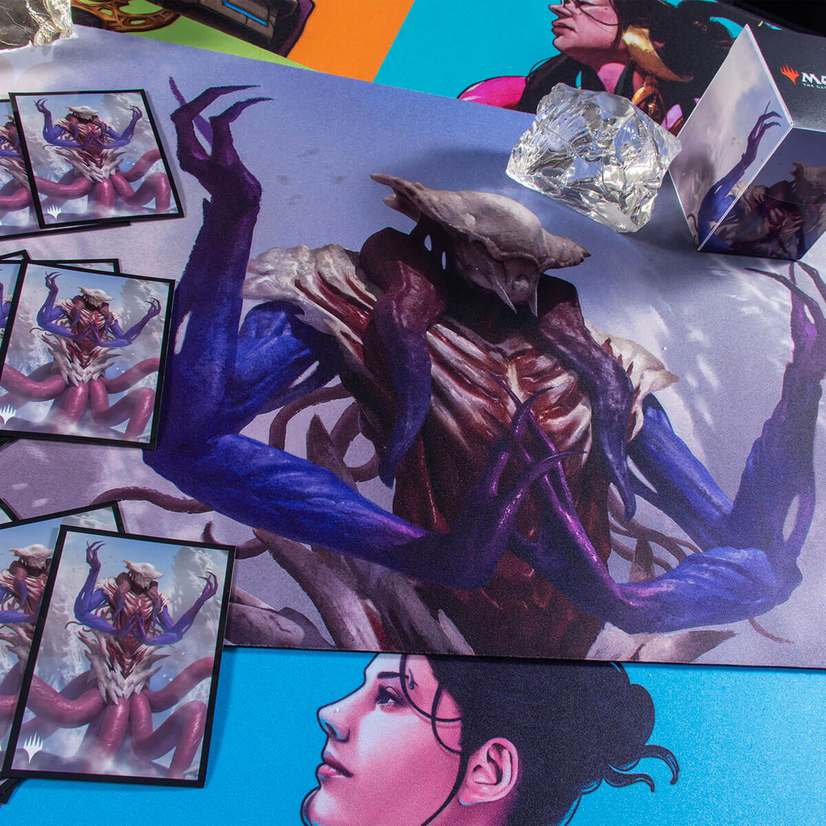 A Magic: The Gathering playmat featuring Zhulodok, Void Gorger, with several card sleeves and dice. Brand: Ultra PRO, Item: Commander Masters Zhulodok, Void Gorger Standard DECK PROTECTOR® Sleeves (100ct).