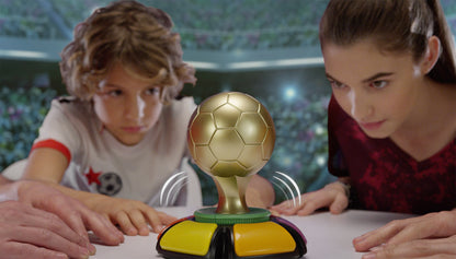 A golden soccer ball trophy on a game board with colorful buttons, played by two children in a stadium setting. Fanzone Trivia Game Bundle.