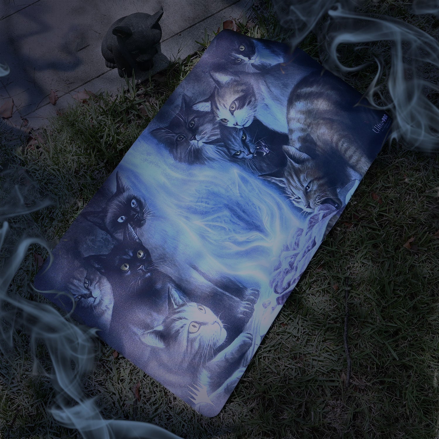 A blue and purple gaming playmat featuring a group of cats with glowing eyes, surrounded by magical energy. Brand: Ultra-Pro, Item: Innistrad: Midnight Hunt Can’t Stay Away Standard Gaming Playmat.