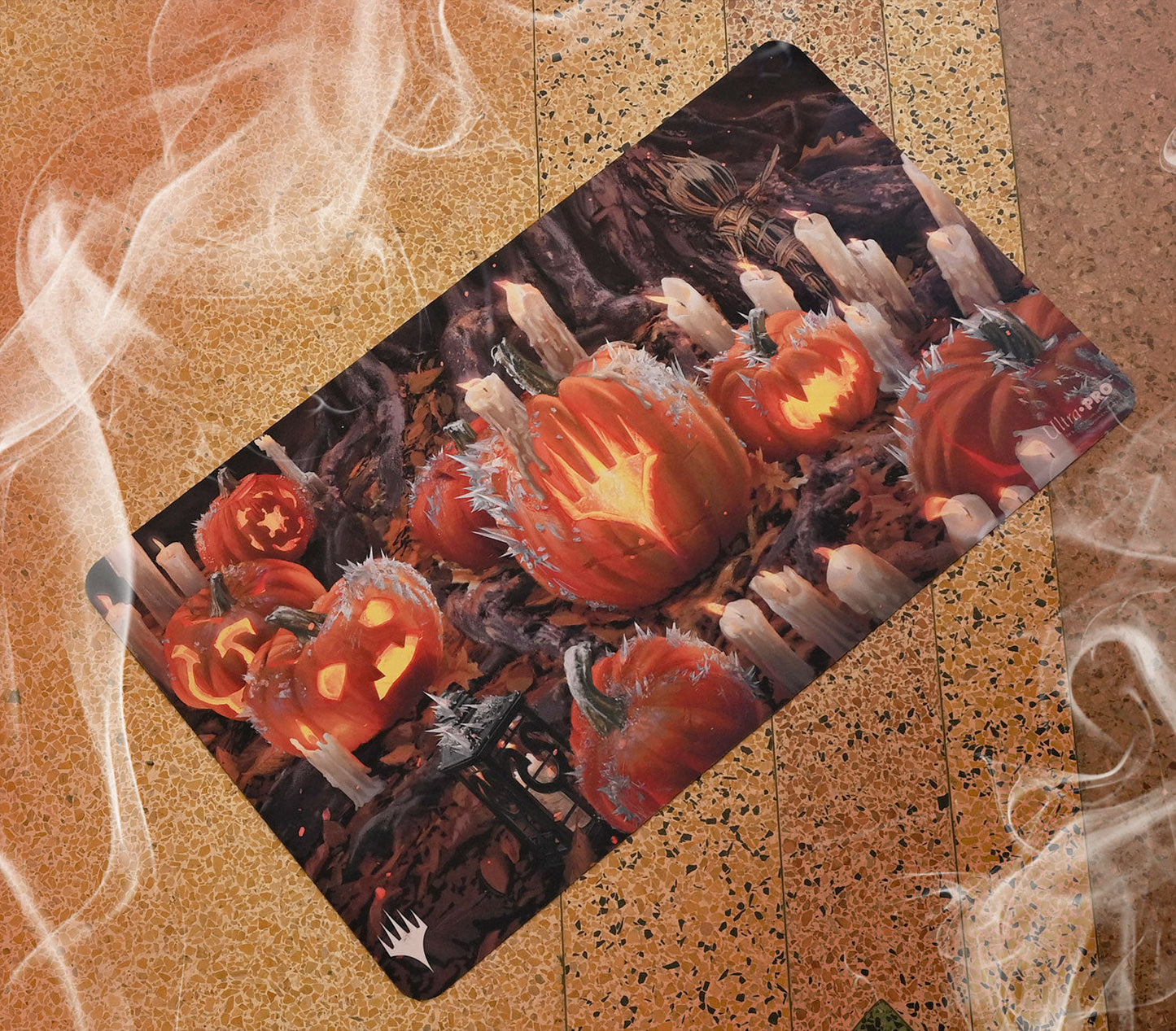 A stylized Magic: The Gathering playmat featuring carved pumpkins and candles with a spooky Innistrad theme. Brand: Ultra-Pro, Item: Innistrad: Midnight Hunt Stylized Planeswalker Symbol Standard Gaming Playmat