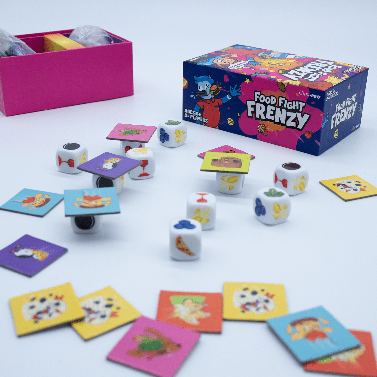 A board game set for Food Fight Frenzy, featuring dice, cards, and a game box. Brand: nan, Item: Food Fight Frenzy – A Silly, Fast Action Game for Family Fun.